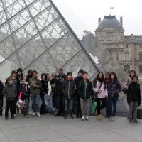 Die deutschen Schülerinnen und Schüler zusammen mit ihren Austauschpartnern vor der großen Pyramide im Innenhof des Louvre