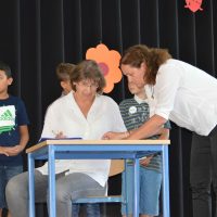 Eine Mutter unterschreibt stellvertretend für die Eltern der Fünftklässler die Erziehungsvereinbarung