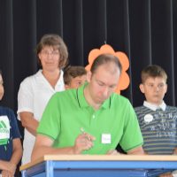 Eine Lehrer unterschreibt die Erziehungsvereinbarungen